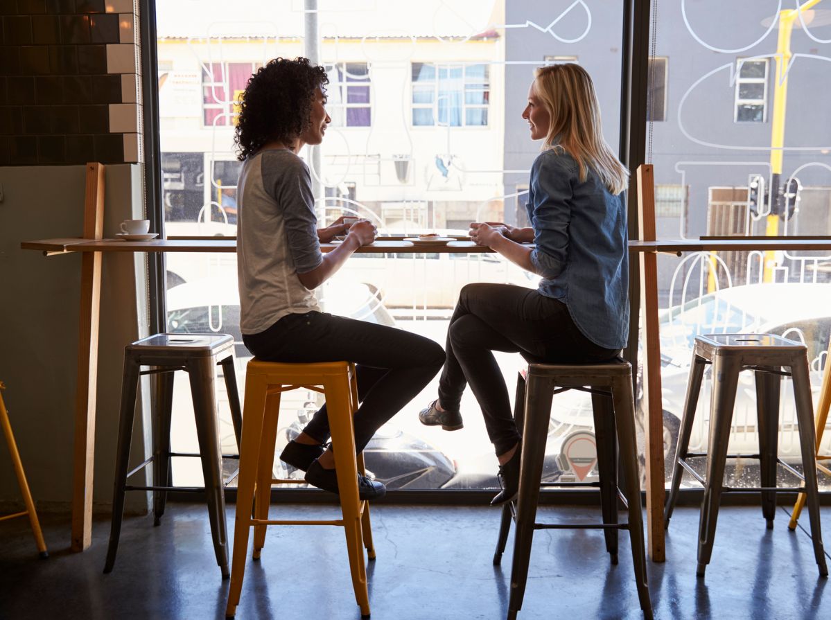 Two friends enjoying a conversation over coffee in a cozy cafe